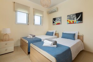 Une chambre d’hôtel avec deux lits, une table de chevet avec une lampe et des œuvres d’art accrochées aux murs.
