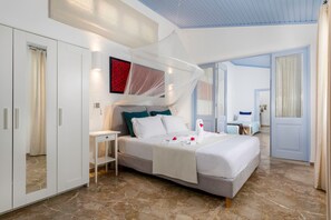 A modern bedroom with a large bed, a wardrobe, and a bathroom visible through an open door. - Villa Amelie in Rhodes (Rhodes)