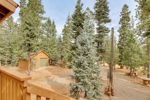 A wooden deck with a small shed and a tall evergreen tree in a forested area. - Game Room, Fire Pit: Dog-Friendly Duck Creek Cabin (Duck Creek Village)
