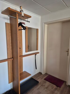 Ein Zimmer mit einer Holzregaleinheit, einer schwarzen Matte und einer Tür.