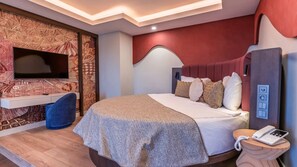 A modern hotel room with a bed, a television, a telephone, and a wall-mounted control panel. - Çenger Blue Collection All Inclusive (Manavgat)