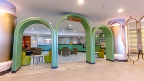 A hotel lobby with green arches, a reception desk, and seating areas. - Çenger Blue Collection All Inclusive (Manavgat)