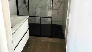 Een badkamer met een douche, wastafel en toilet.