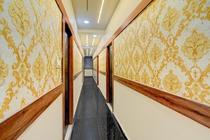 A corridor with patterned wallpaper and wooden trim, leading to a door at the end. - Hotel O Gachibowli Crossway Hyderabad (Hyderabad)