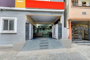 A building entrance with a gated driveway, a reception desk, and a staircase leading to the entrance. - Hotel O Gachibowli Crossway Hyderabad (Hyderabad)