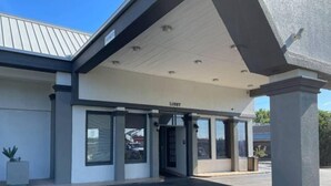 A building with a covered entrance labeled 'LOBBY' and a clear sky above. - 1 King Bed|Smoking|Opelika, AL (Opelika AL)