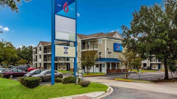 Een motel met een bord waarop staat dat er 6 kamers beschikbaar zijn voor $49,99.
