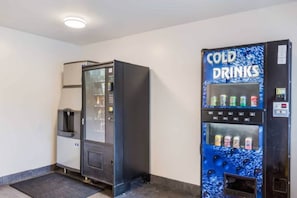 A vending machine with a blue exterior and the words 'COLD DRINKS' on it, and a separate vending machine with a glass door. - Cozy Queen Bed ADA Room|Free Wifi (Jacksonville)
