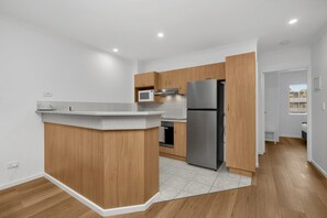 Eine moderne Küche mit einer zentralen Kochinsel, integrierten Geräten und einem hellen, weißen Interieur.
