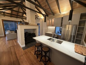 Een moderne keuken met een centraal eiland, barstoelen en een inbouwoven.