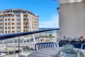 Ein Balkon mit Blick auf ein Hotelgebäude und einen Strand.