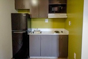 Cocina compacta con refrigerador, lavaplatos y microondas.