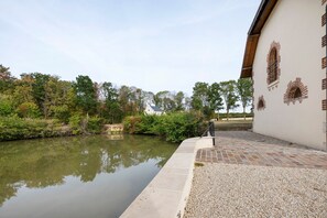 En lugn innergård med en fontän, en grusgång och en byggnad med ett karakteristiskt murverk.
