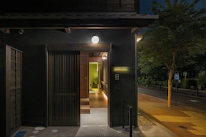 An entrance to a building with a wooden door, a ramp leading inside, and a sign indicating a hotel. - HITOTOSE HARU -Kyoto Gion Shirakawa- (Kyoto)