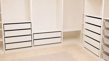 A walk-in closet with open shelving, hanging space, and drawers.