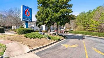 A sign for a 6 Kitchen Efficiencies building with a parking lot in front.