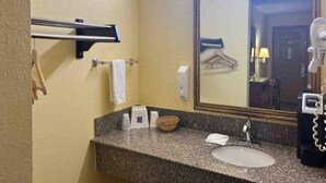Un bagno con un piano in granito, un lavandino, un porta asciugamani, uno specchio e un asciugacapelli.