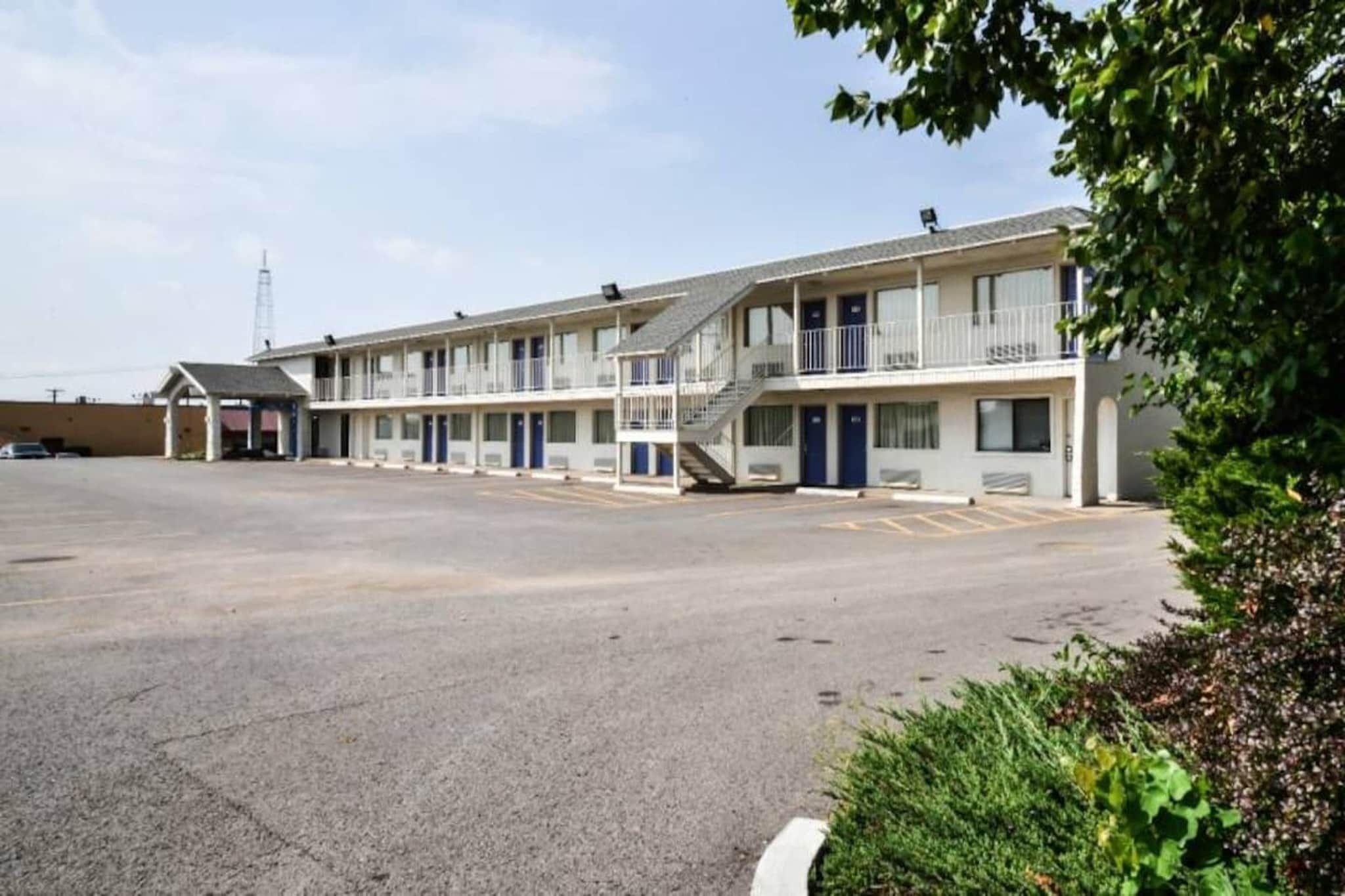 A motel with a central parking area and multiple rooms with balconies.