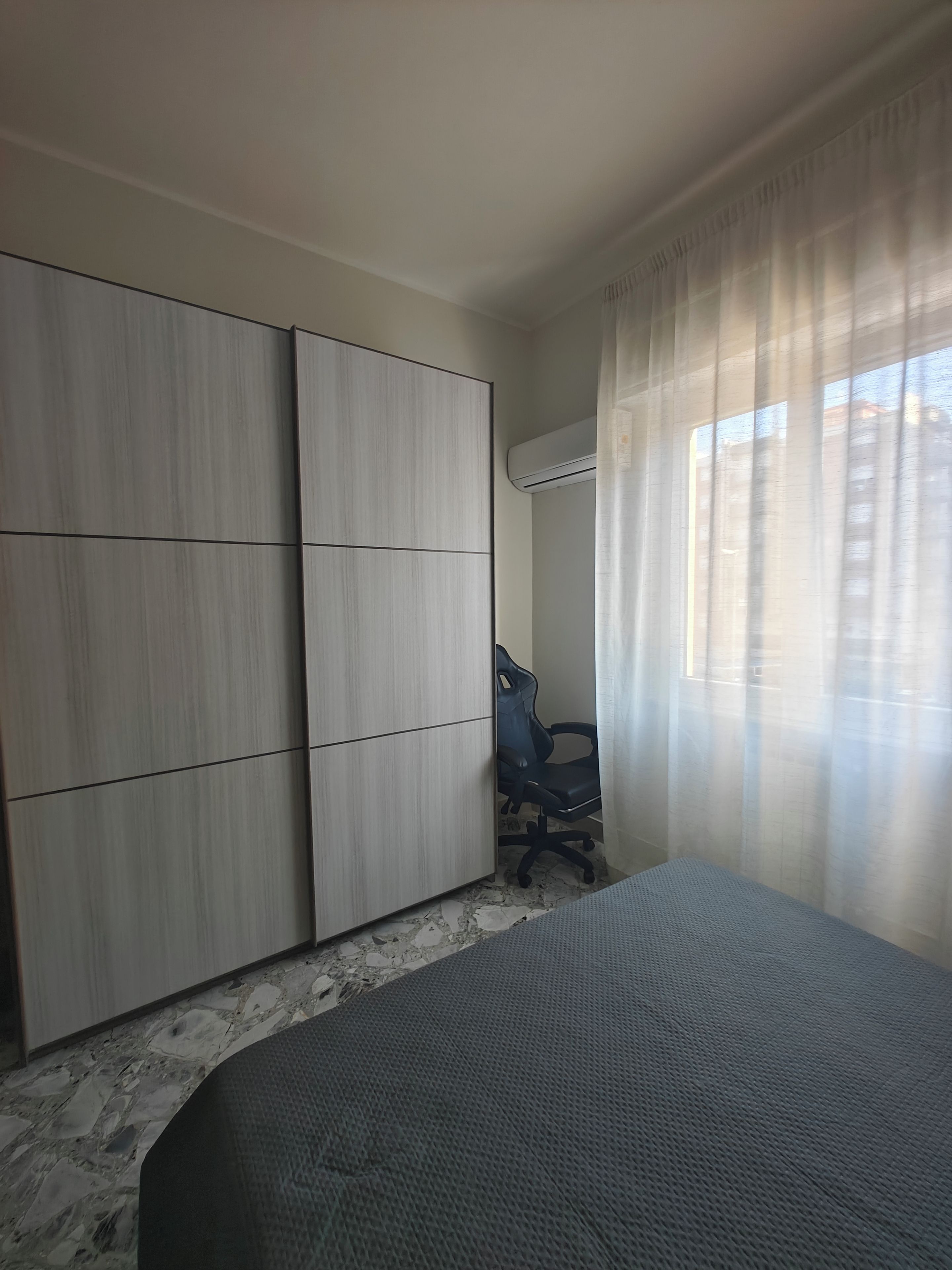 Un dormitorio con una cama, un escritorio y un armario.