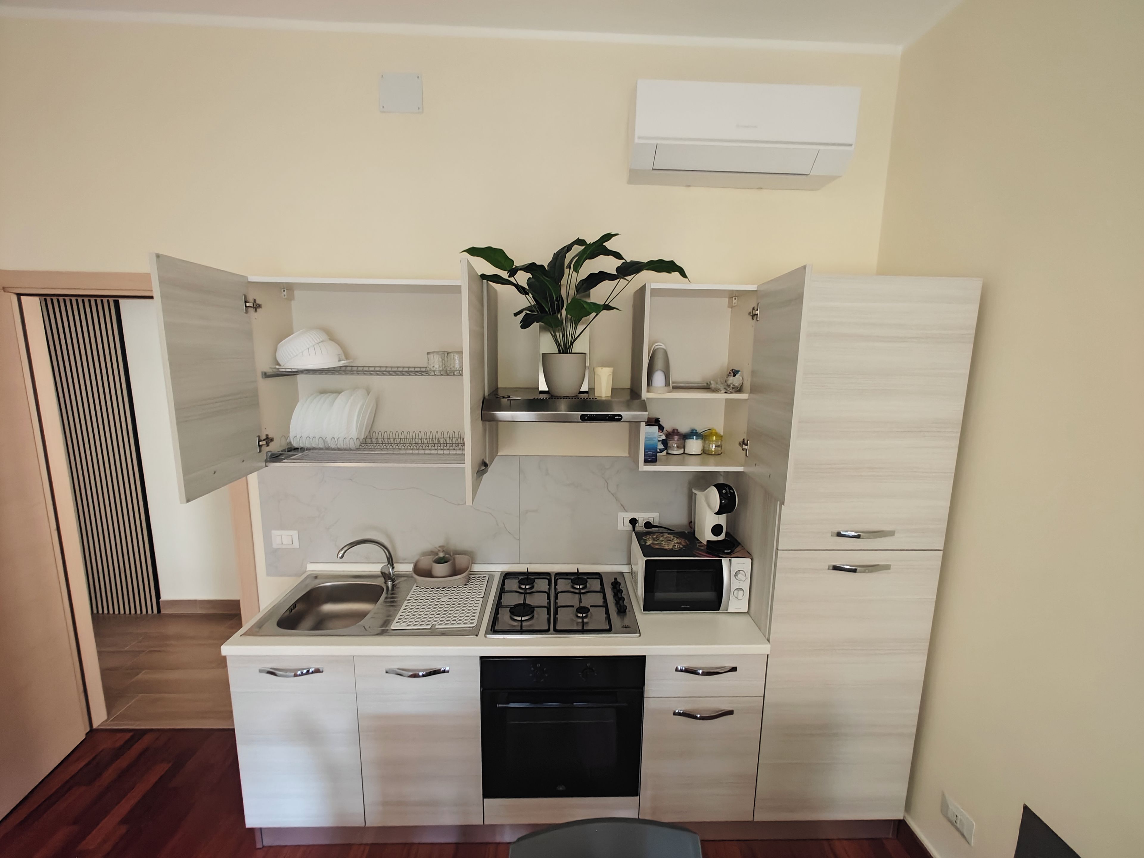 Una cocina compacta equipada con lavavajillas, estufa a gas y microondas.