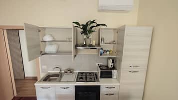 Una cocina compacta equipada con lavavajillas, estufa a gas y microondas.