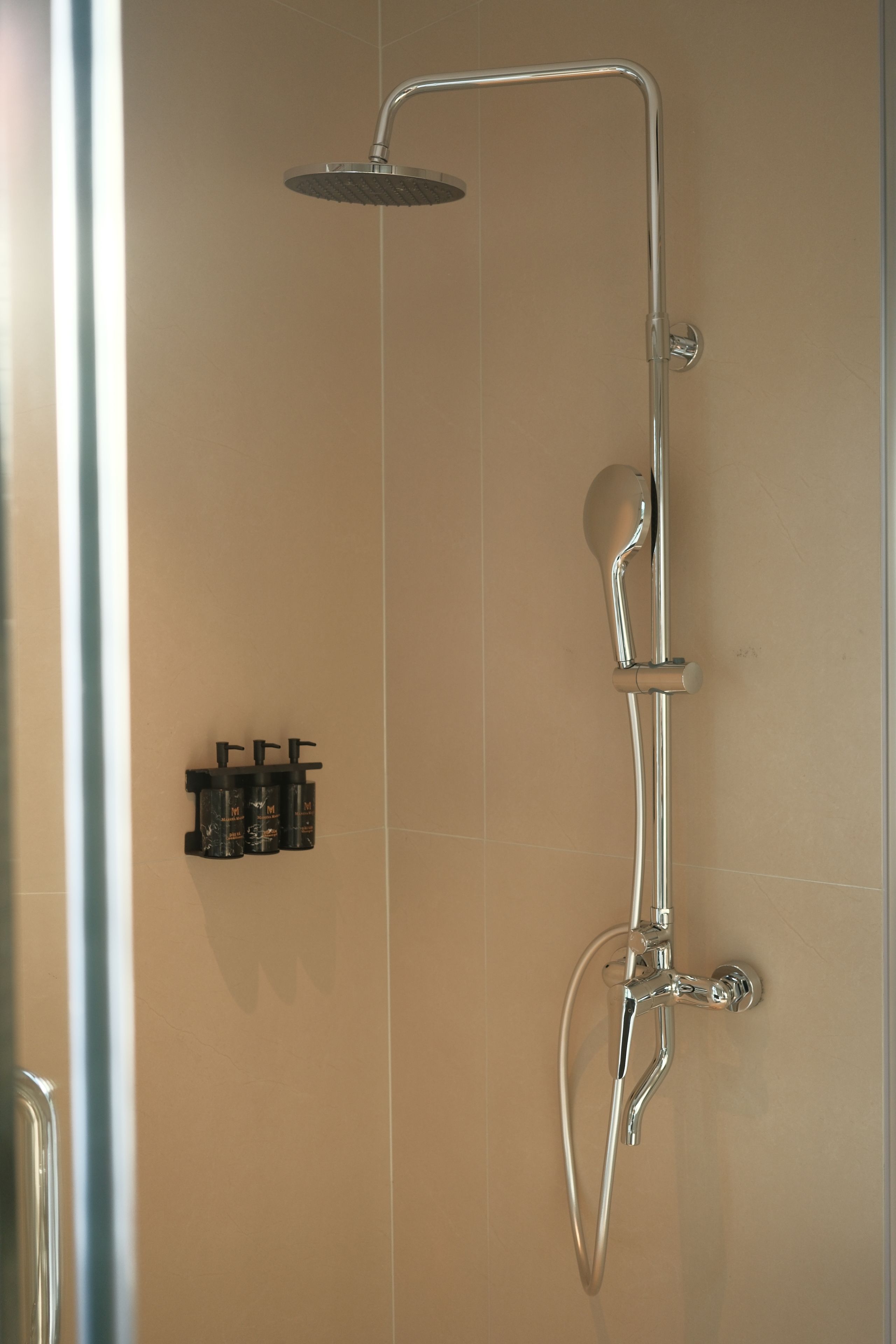 Een douche met een handdouche en een wandmengkraan.