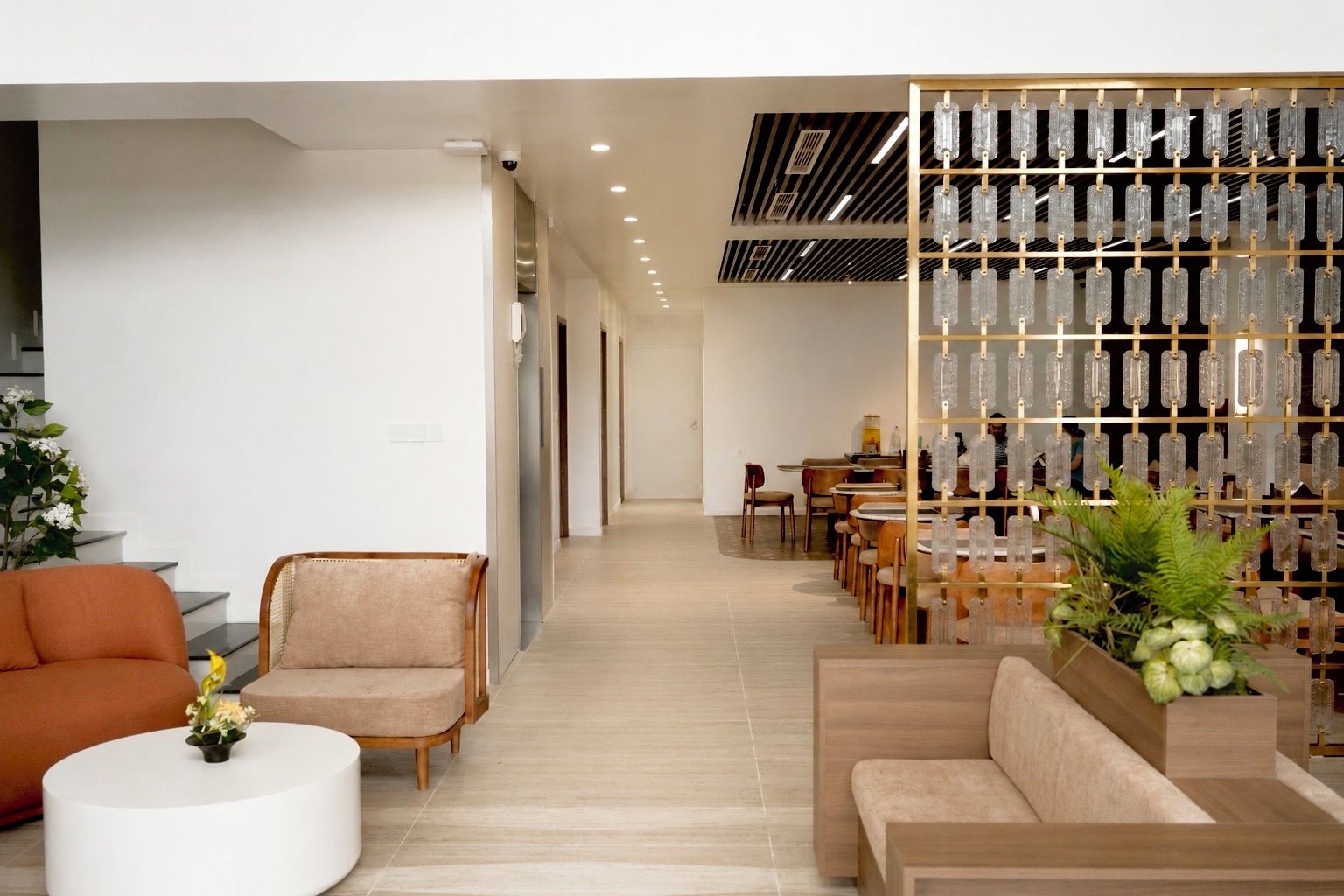 A modern interior with a seating area, a dining section, and a decorative glass display.