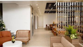 A modern interior with a seating area, a dining section, and a decorative glass display.