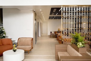 A modern interior with a seating area, a dining section, and a decorative glass display.
