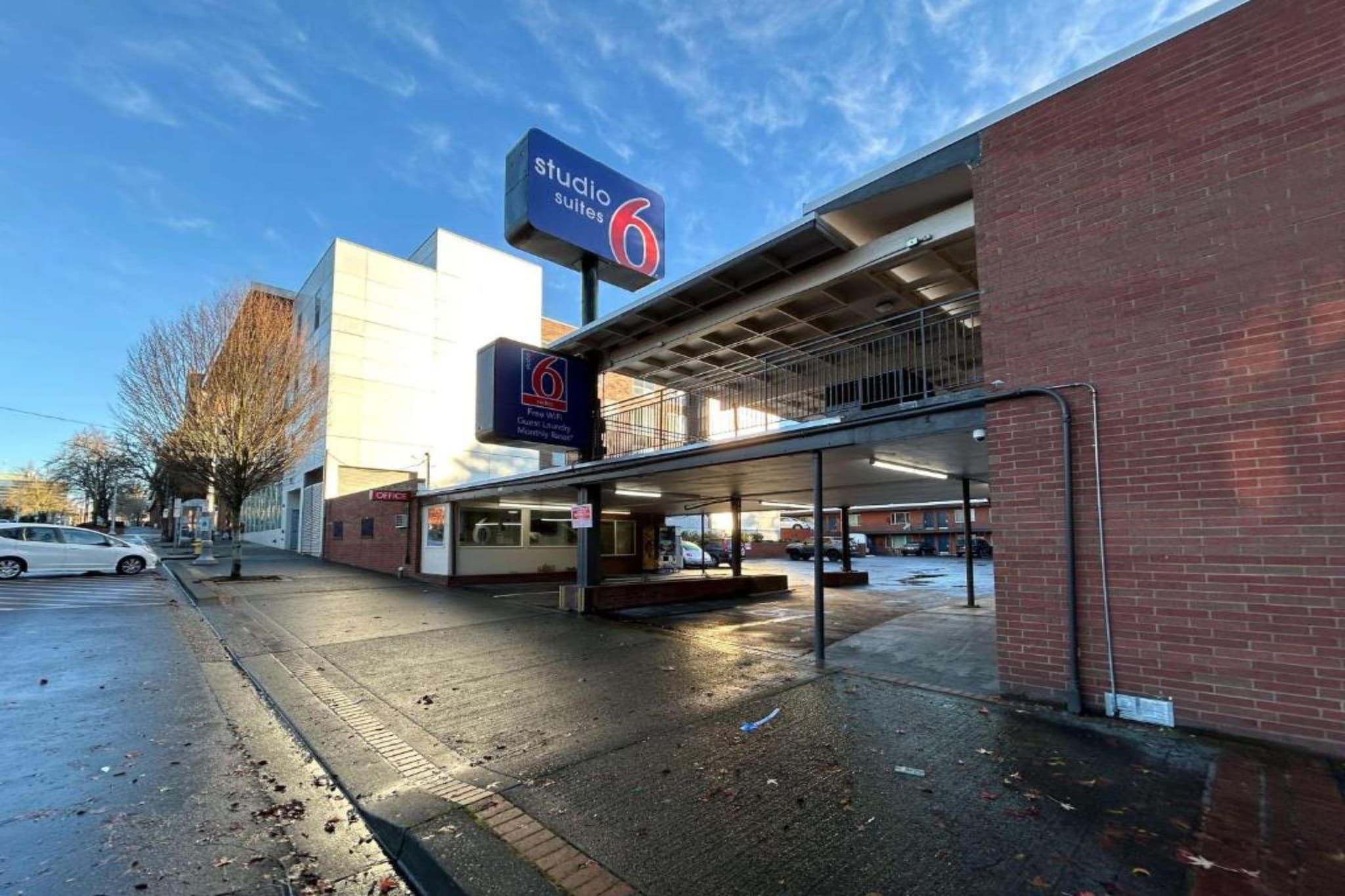 En hotellentrén med en skylt som visar ”Studio 6 Suites” och en skylt som anger ”kostnadsfritt Wi-Fi”.