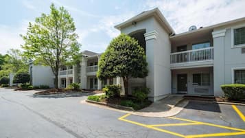 A multi-story residential building with a parking area in front.
