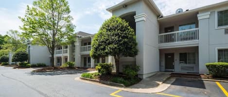 A multi-story residential building with a parking area in front.