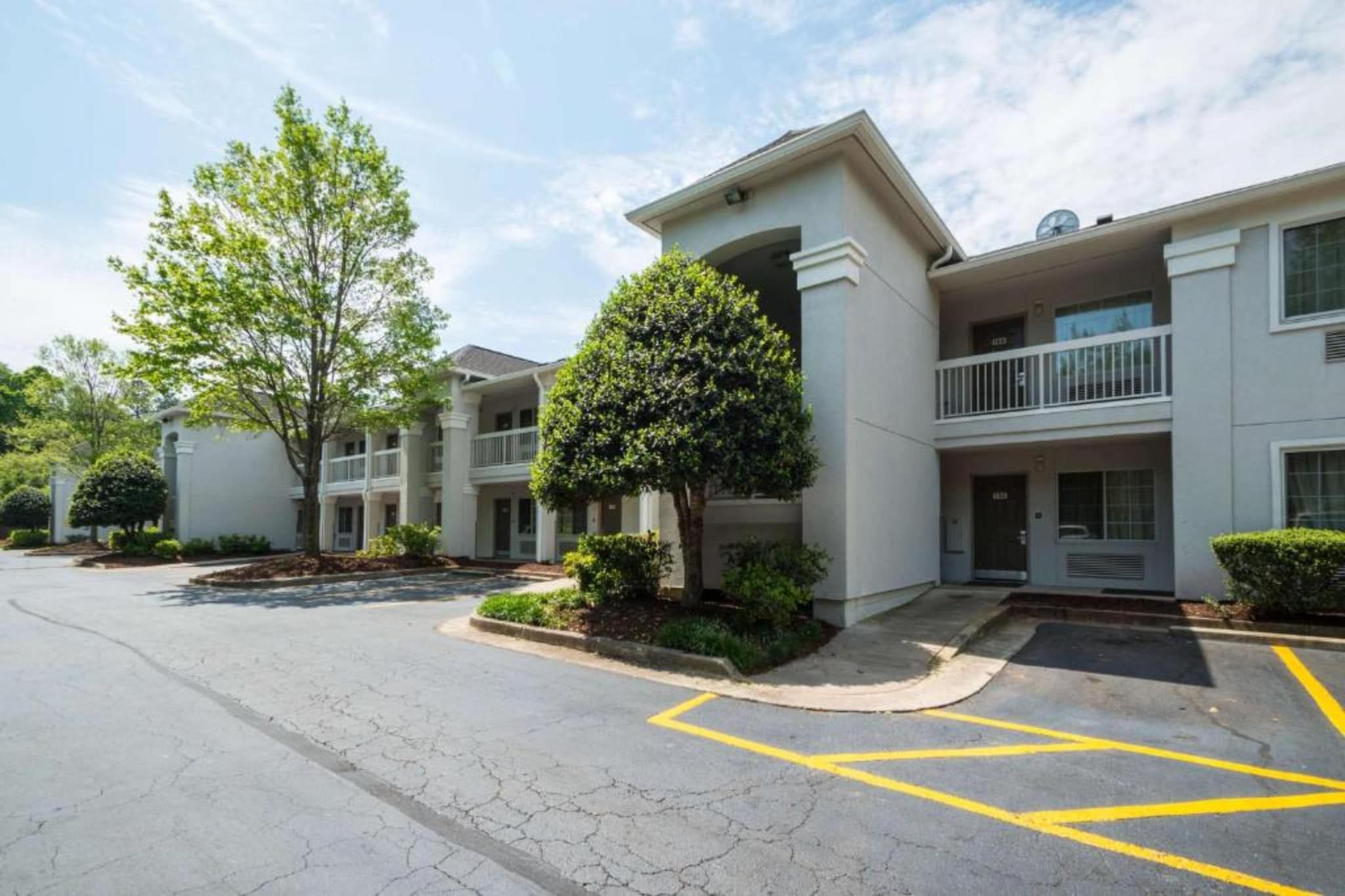 A multi-story residential building with a parking area in front.
