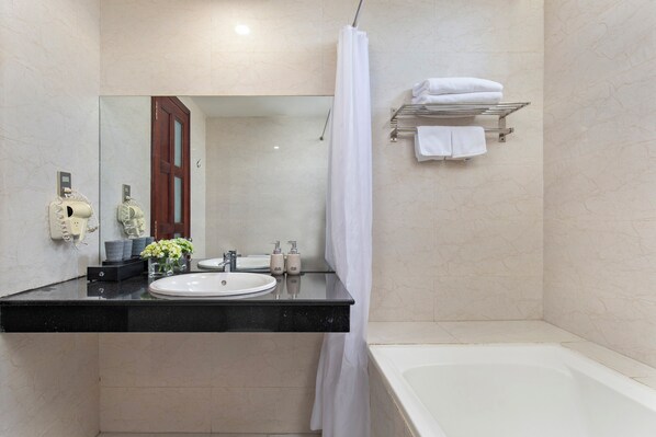 A bathroom with a sink, mirror, shower, and a towel rack. - Le Charmant Da Nang (An Hai)