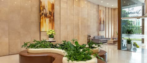 A modern lobby with a curved seating area, a sofa, and a coffee table.