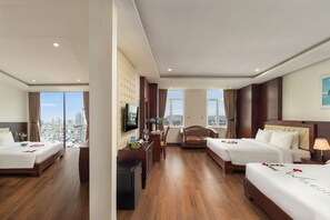 Une chambre d’hôtel avec deux lits, un bureau, une télévision et une vue sur la ville.