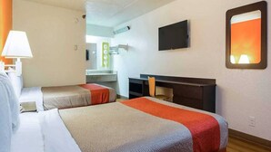 A hotel room with two beds, a desk, a chair, a TV, and a bathroom visible in the background. - Spacious 2-bed ADA Room|Free Wifi (Tucker)