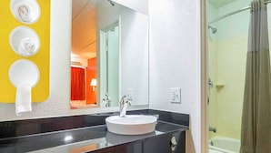 A bathroom with a round sink, a mirror, and a shower area. - Spacious King Bed|Vending Machine (Tucker)