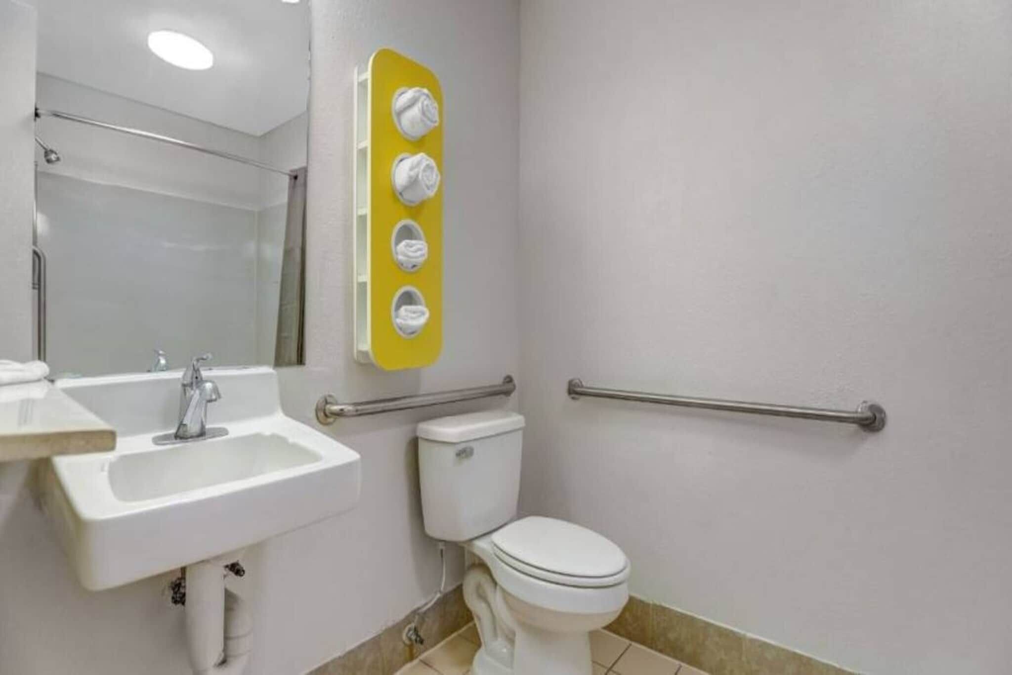 Un bagno con lavandino, WC e specchio.