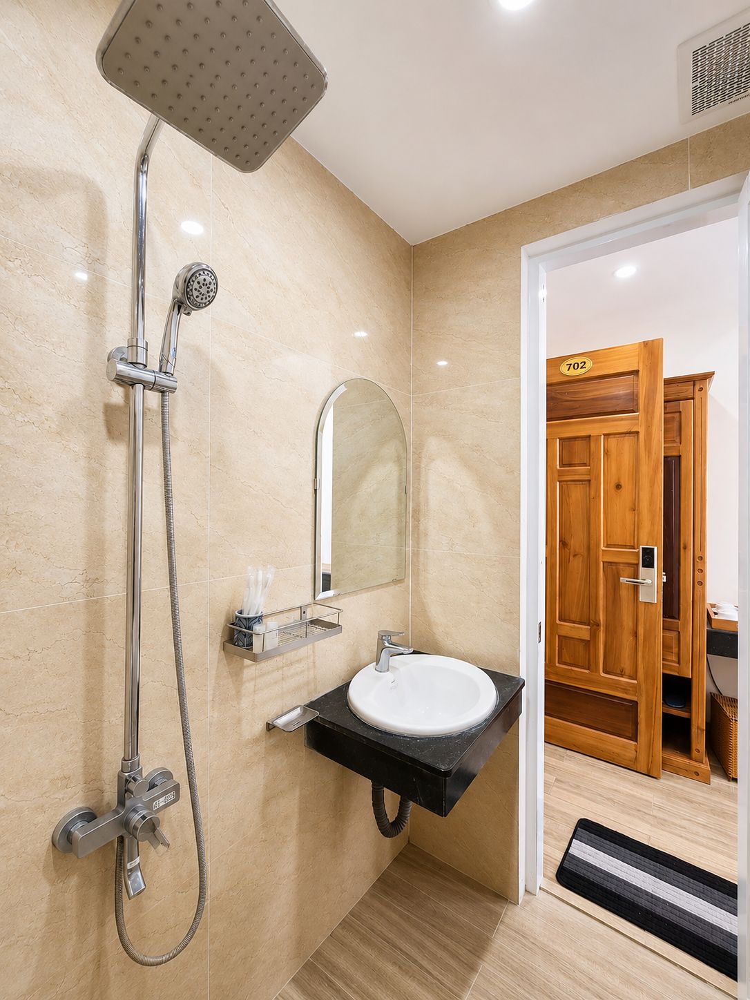 Un baño moderno con ducha, lavamanos y espejo.
