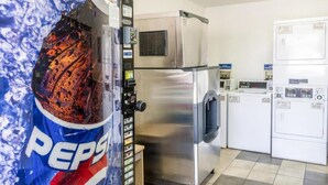 Une cuisine équipée d’appareils électroménagers en acier inoxydable, notamment un réfrigérateur, un four à micro-ondes et un lave-linge.