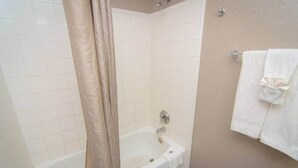 Un bagno con una vasca, una tenda da doccia e un portasciugamani con un asciugamano.