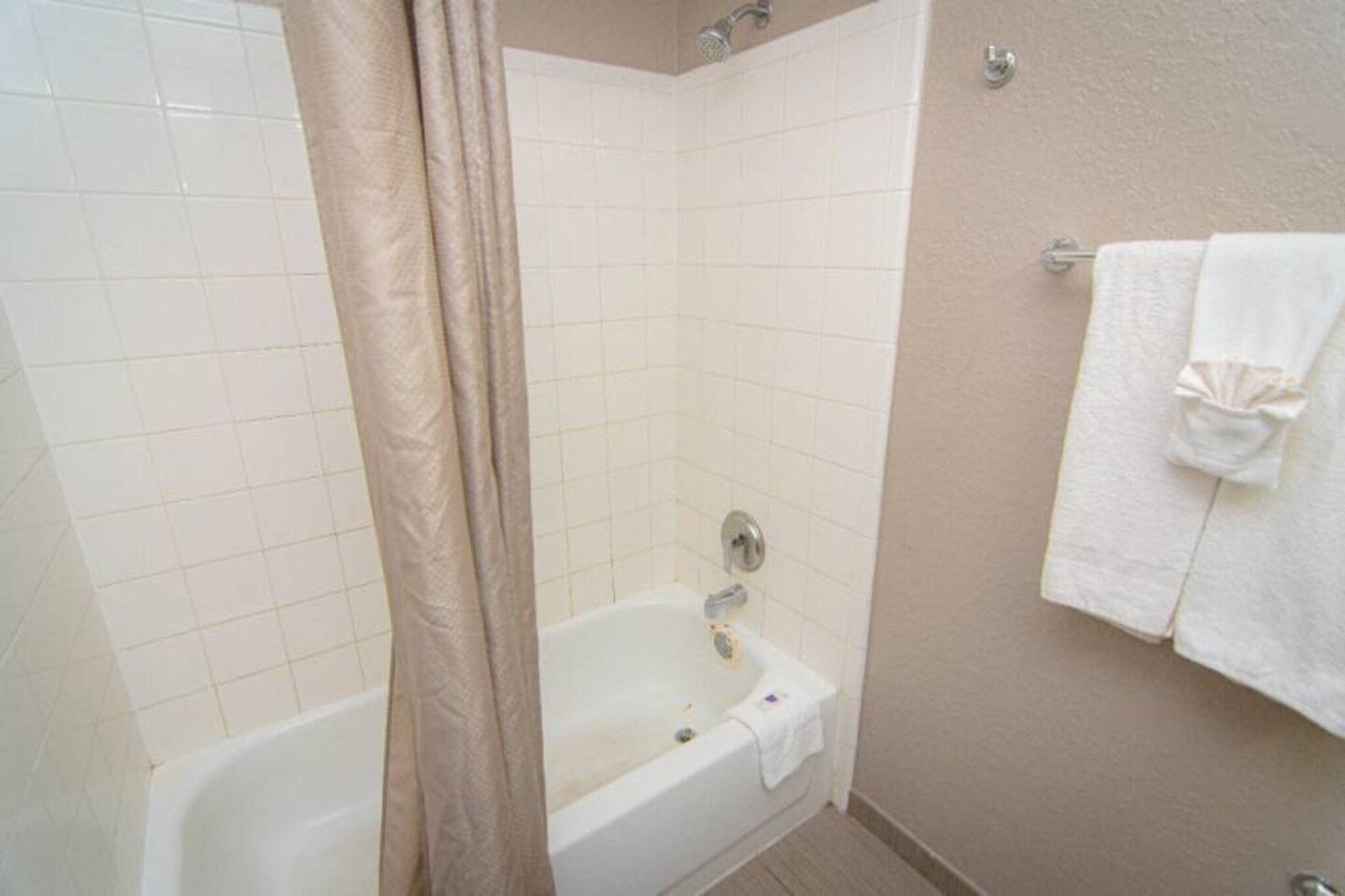 Une salle de bain avec une baignoire, un rideau de douche et un porte-serviettes.