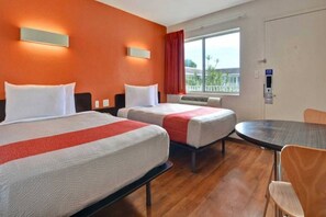 A hotel room with two beds, a small table, and a window with a view. - 2 Full Beds|Mini Fridge,Smoking (Dania Beach)