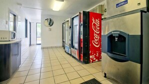 A kitchen area with a microwave, a refrigerator, and a Coca-Cola vending machine. - 2 Full Beds|Mini Fridge,Smoking (Dania Beach)