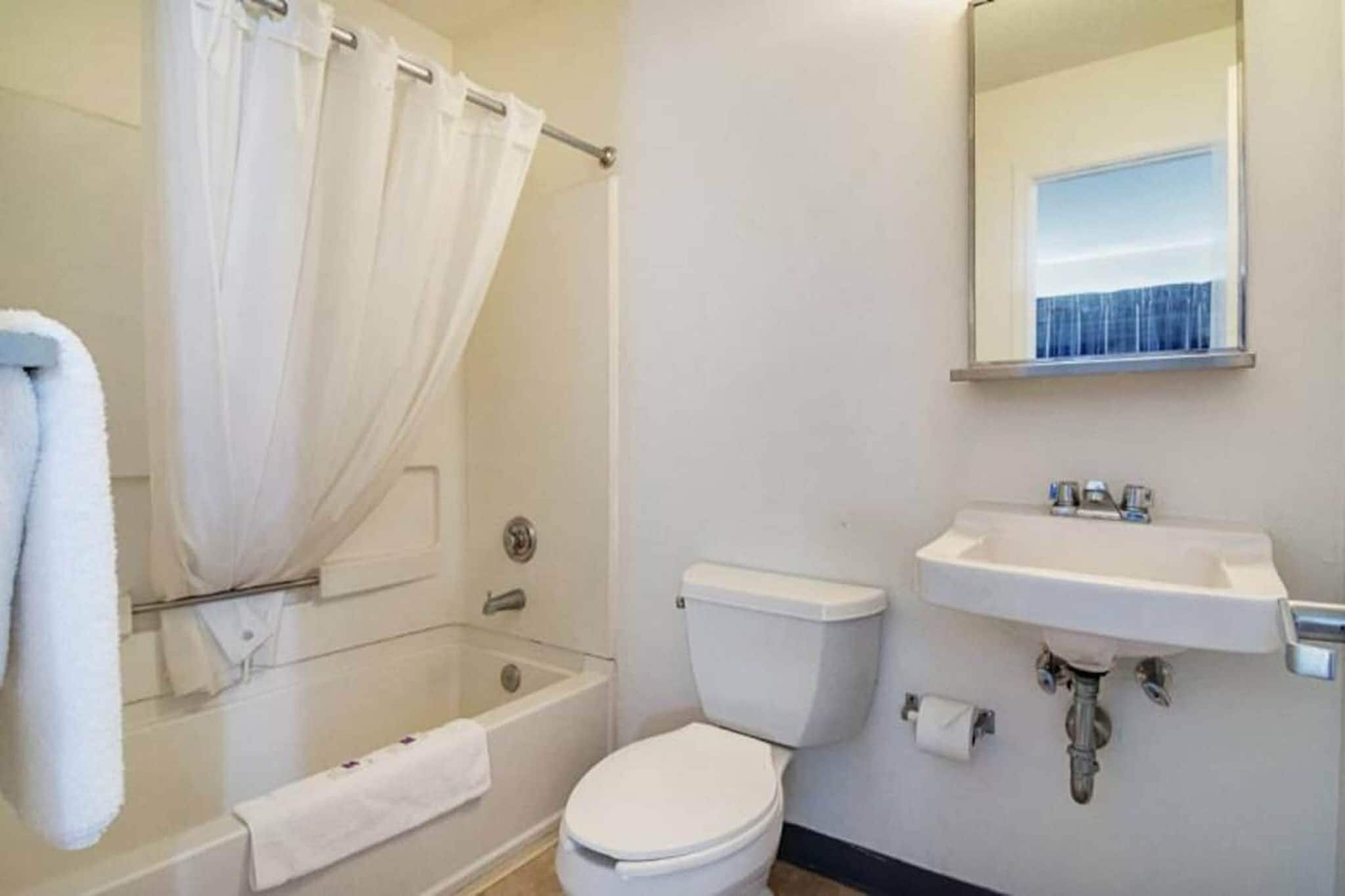 A bathroom with a bathtub, toilet, and sink.