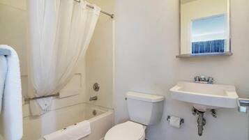 A bathroom with a bathtub, toilet, and sink.