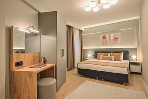 Une chambre à coucher moderne avec un lit, des tables de chevet, un bureau et un grand miroir.