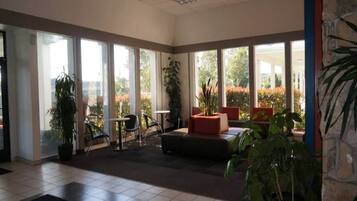 Un hall amplio con ventanas grandes, mostrador de recepción y zonas de estar.