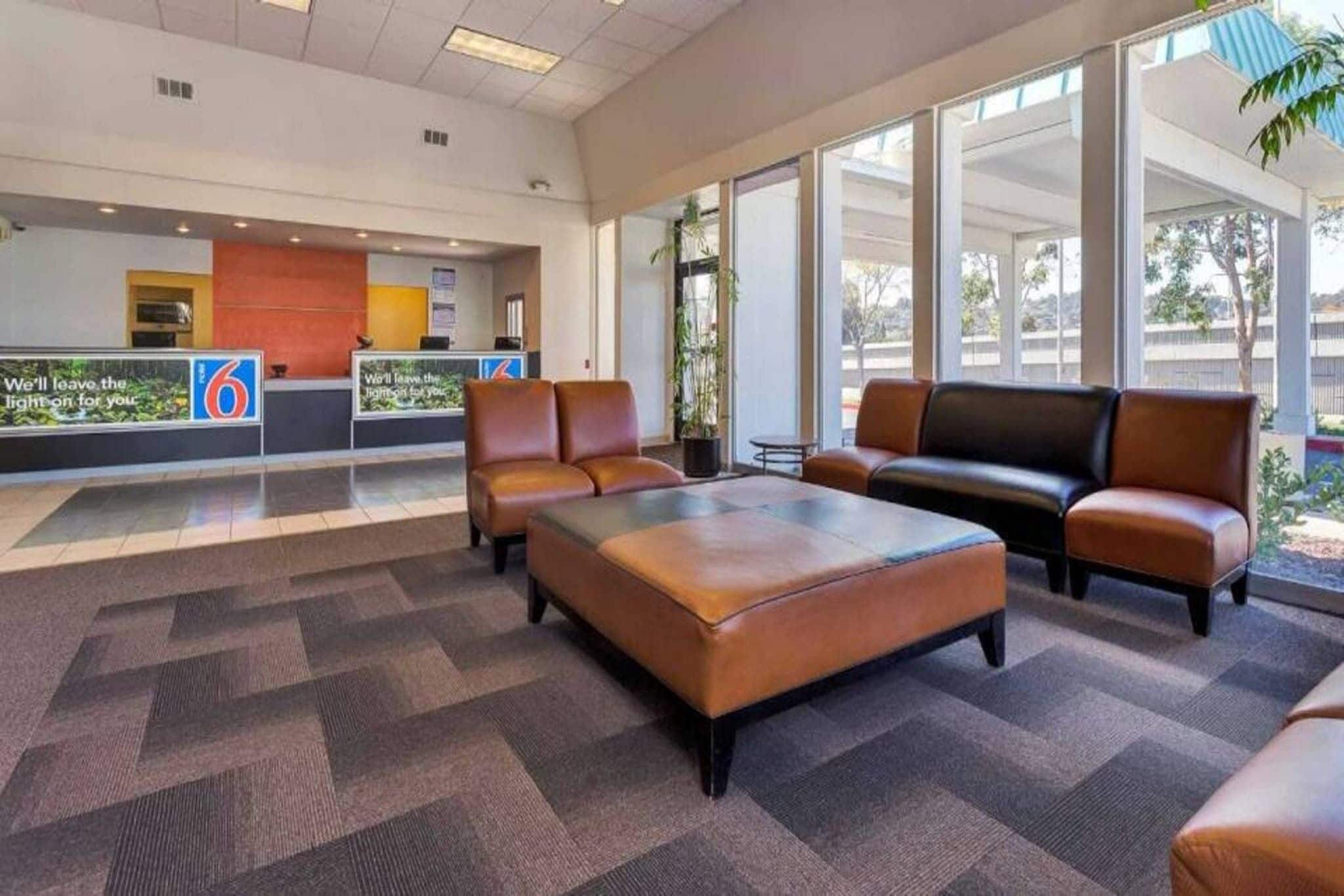 A lobby with a reception desk, seating area, and large windows.